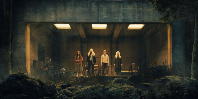 Détail de l'affiche, représentant un groupe d'individus enfermés dans un bunker, disposés derrière une vitrine, au milieu d'une forêt menaçante.